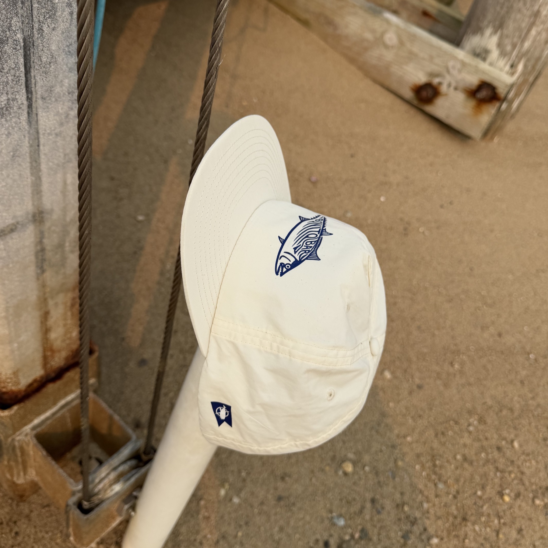 Close detail of the Bonito Bar hat with navy artwork.